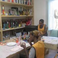 Kaks Eritrea tütarlast valmistavad selles töökojas Aafrika motiividel puunukke, mis lähevad peagi maailmakaubandusse (ikka Fair Trade märgi all) ringlema ja tütarlastele elatist teenima. Nagu ka kõik teised töökojad Riaces, on ka see loodud valitsuselt eraldatud toetussummade abil